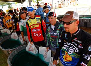 2011 Bassmaster Elite Series weigh in tent with tournament anglers waiting in line with their bass 2011 Bassmaster Elite Series weigh in tent with tournament anglers waiting in line with their bass
