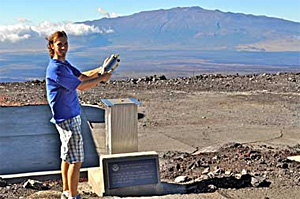 Aidan Colton at NOAA's Mauna Loa Observatory (MLO) demonstrates how early flask samples were filled at the site. Air collected year-round at MLO and eight other remote sites around the world has been analyzed for the industrial solvent methyl chloroform. Variability in the decay of this chemical has helped scientists understand the oxidizing or cleansing power of the global atmosphere and its sensitivity to natural and human-induced perturbations. Photo Credit: NOAA