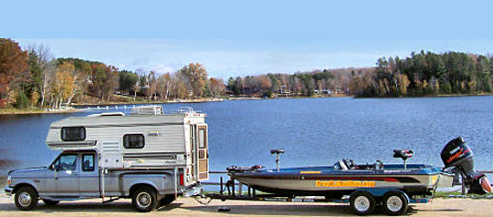 Pickup camper and bass boat on trailer