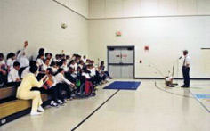 Dan Kimmel in Williamston school gym performing a bass seminar